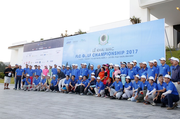 Golfers of the first day of competition take photos before teeing off.