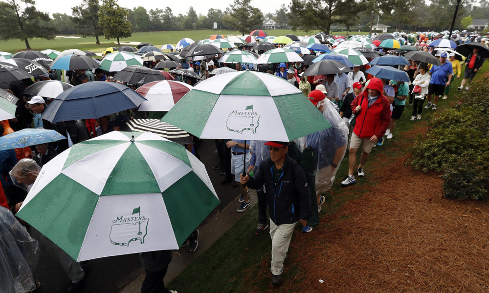Khán giả ra về sau khi sân Augusta National bị ngập bởi mưa bão