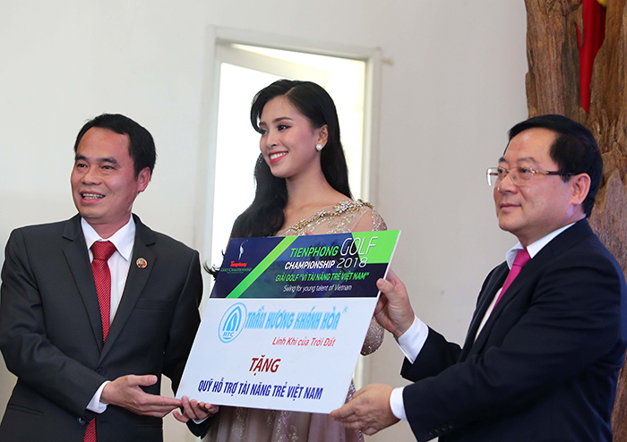 Ông Lê Xuân Sơn - Tổng biên tập báo Tiền Phong và Hoa hậu Trần Tiểu Vy nhận 2 cây trầm hương của Công ty Trầm hương Khánh Hoà làm quà đấu giá tại tiệc trao giải.