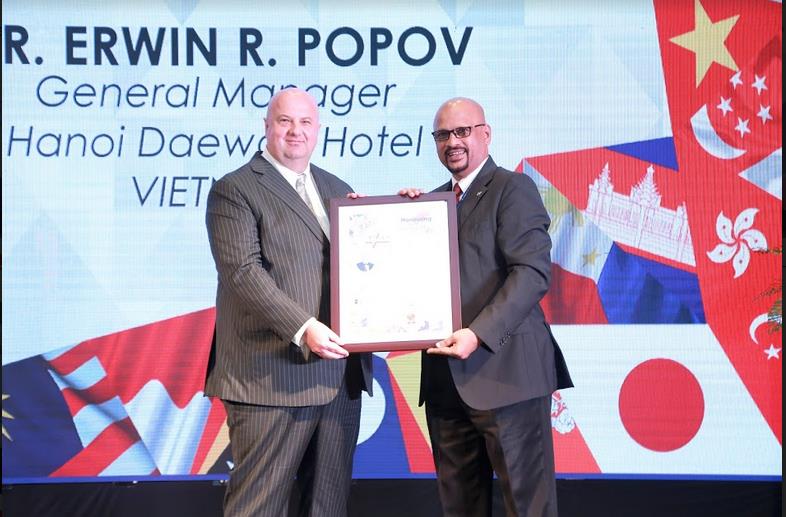 Ông Erwin R. Popov – Giám đốc khách sạn Hà Nội Daewoo đón nhận bộ đôi giải thưởng dành cho khách sạn & cá nhân xuất sắc từ ông Adeva Sangkuni - Chủ tịch Liên đoàn Du lịch và Lữ hành Châu Á Thái Bình Dương APTTF