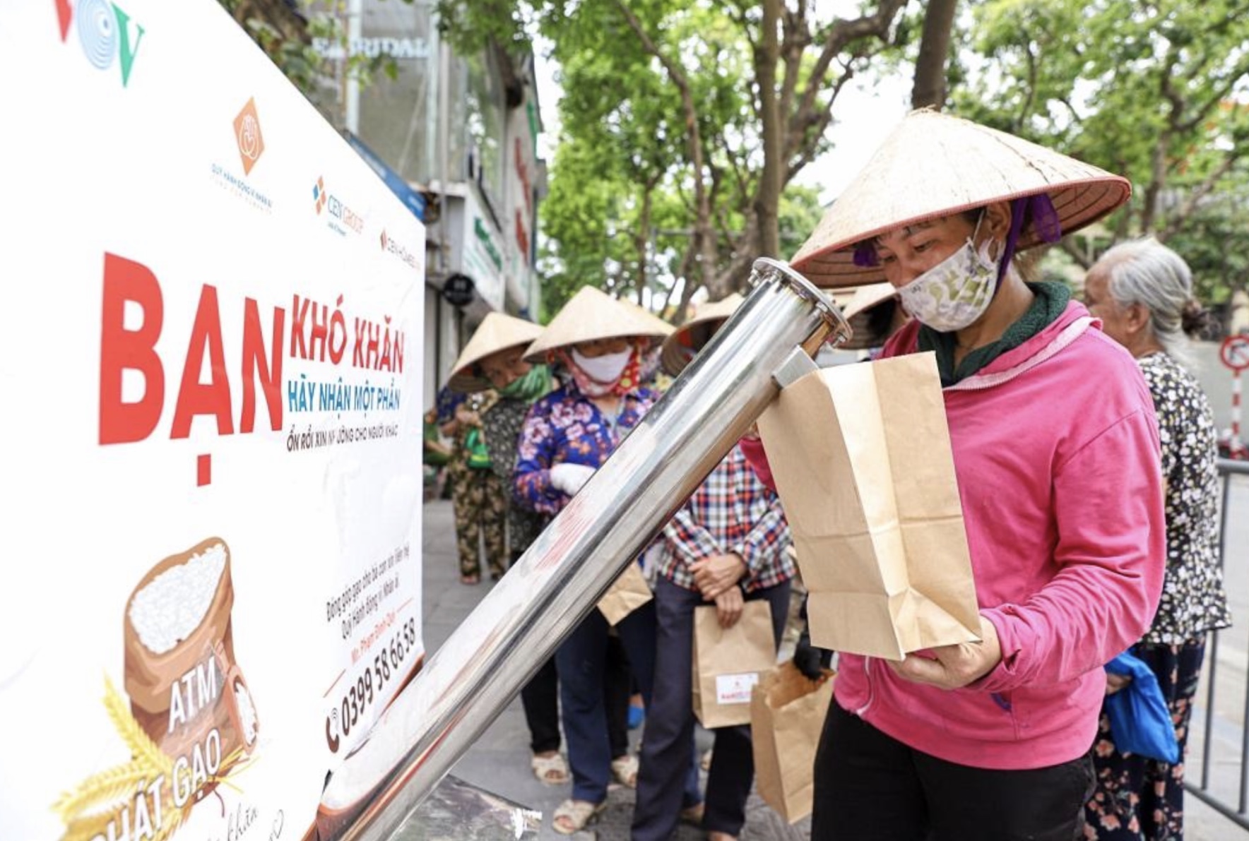 Người dân xếp hàng nhận gạo miễn phí từ Cây ATM gạo, đặt tại 58 Quán Sứ, Hà Nội.