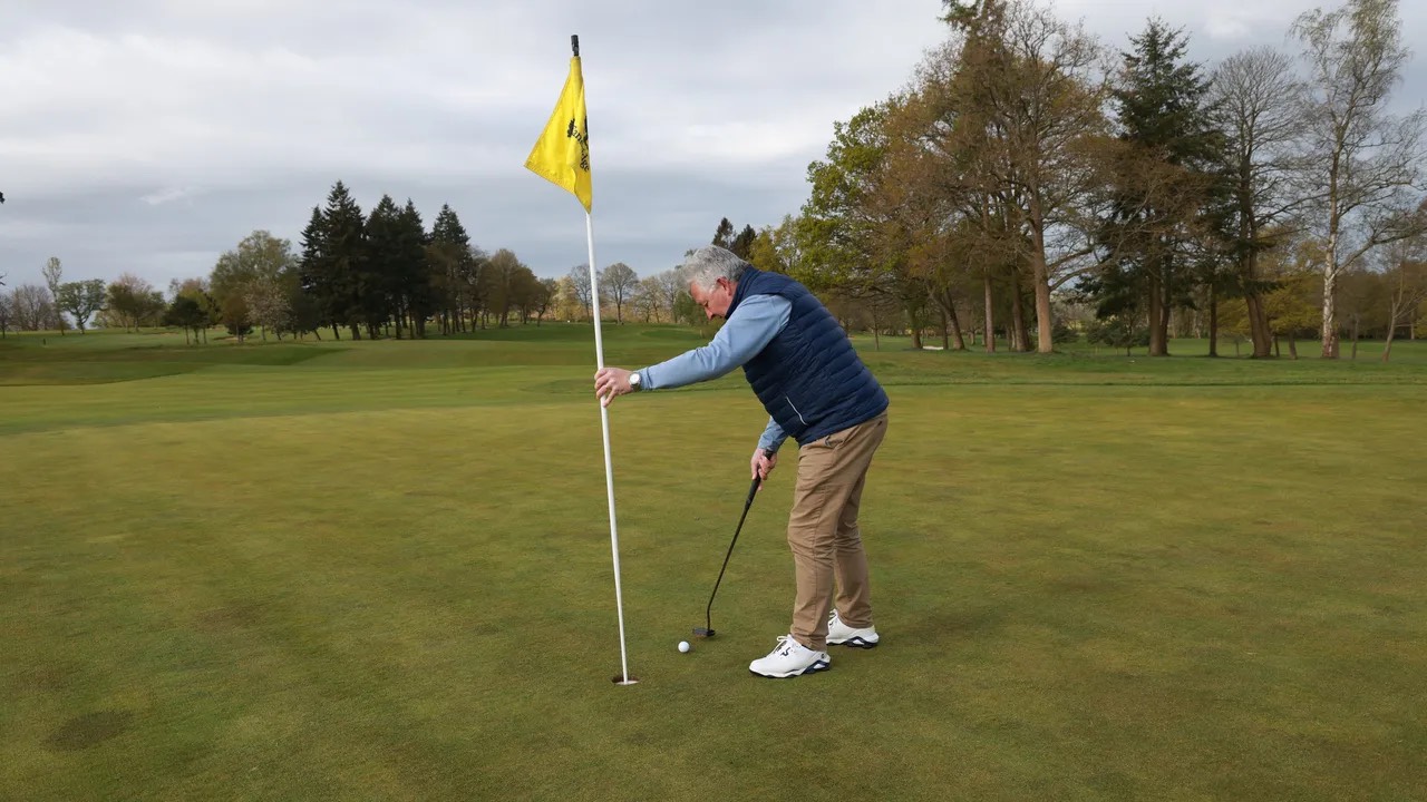 Vừa putt vừa cầm cờ, golfer có bị phạt?